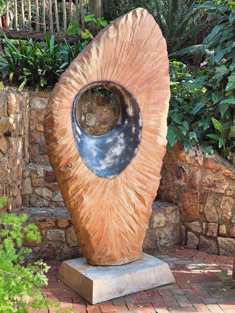 Abstract stone sculpture with a polished opening in a garden