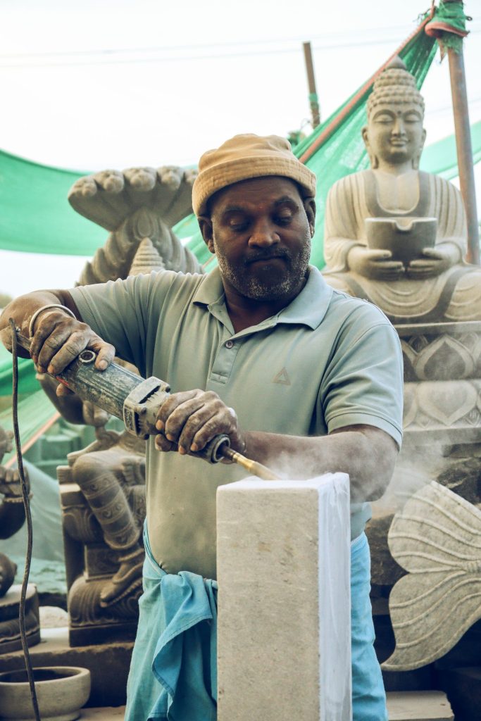 Sculptor refinishing a stone piece in a workshop